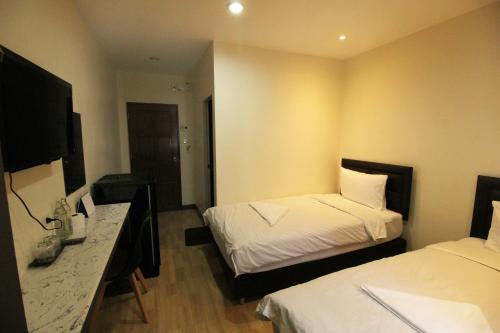 曼谷采瓦旅舍的酒店客房配有两张床和一张书桌