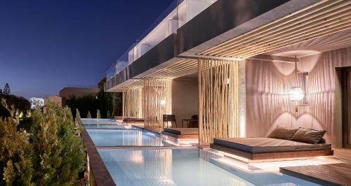 赫索尼索斯NEMA Design Hotel & Spa - Adults Only的一座带游泳池的建筑,上面有一张床