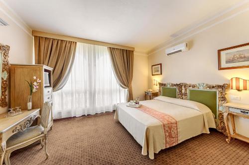 奥尔比亚科隆纳地中海皇宫酒店的酒店客房设有床和窗户。