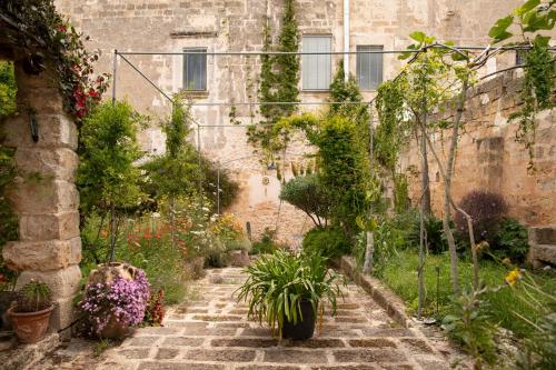 加利亚诺德尔卡波Castle XVIII near sea的一座花园,位于一座种有鲜花和植物的古老建筑中