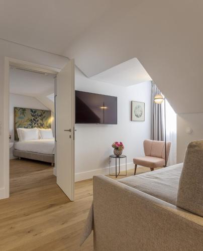 里斯本Lisbon Serviced Apartments - Madalena的配有一张床和一把椅子的酒店客房