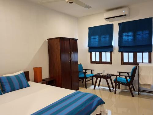 卡卢特勒Lohas Beach Resort Villa的卧室配有一张床和一张桌子及椅子