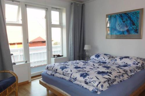 SkudeneshavnCharming flat in cosy farmhouse的一间卧室配有一张带蓝白色毯子的床