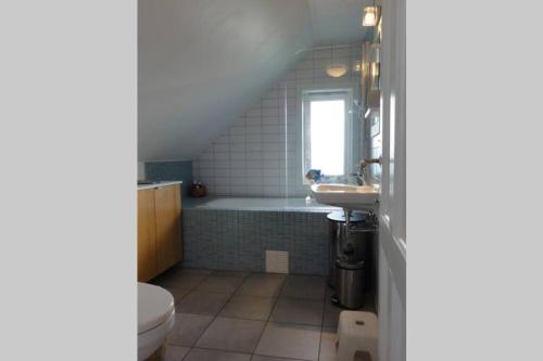 SkudeneshavnCharming flat in cosy farmhouse的带浴缸、盥洗盆和卫生间的浴室