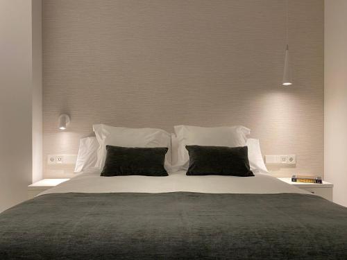 格拉纳达HNN GRANADA的卧室配有一张带黑色枕头的大型白色床。