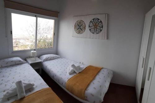 弗龙特拉Casita con Encanto的一间卧室设有两张床和窗户。