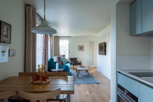 爱丁堡仕骅廷荷里路德艾比史坦公寓酒店的厨房以及带桌椅的起居室。
