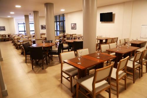 阿拉卡茹皇家海滩酒店的用餐室配有木桌和椅子
