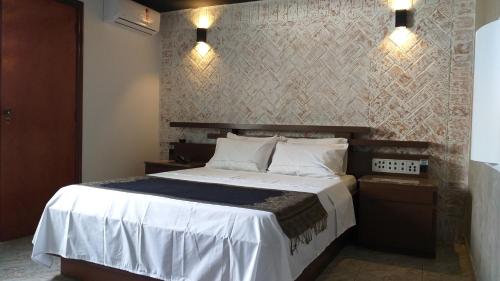 圣保罗Millenium Hotel的卧室配有一张带白色床单和枕头的大床。