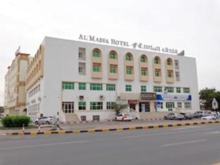阿尔布亚米阿尔马萨1酒店 的一座白色的大建筑,汽车停在停车场