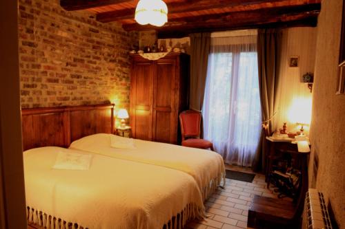 Monthodon拉玛赫莎勒里酒店的卧室配有白色的床和砖墙