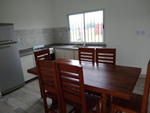 Campo QuijanoQuijaneando的厨房配有木桌、椅子和水槽