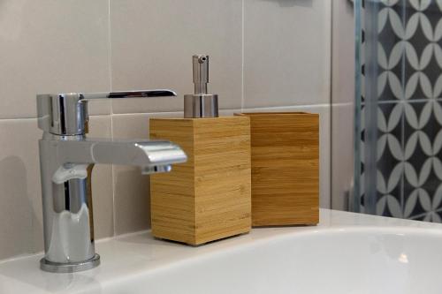 米兰B&B La Terrazza di Barbara的浴室水槽设有水龙头和木架
