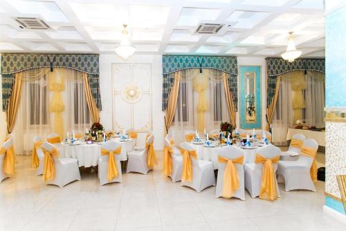 加里宁格勒金色之夜酒店的宴会厅配有白色桌子和黄色弓