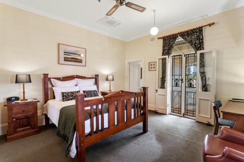 巴利纳Riversleigh House的一间卧室配有一张床、一张桌子和一把椅子