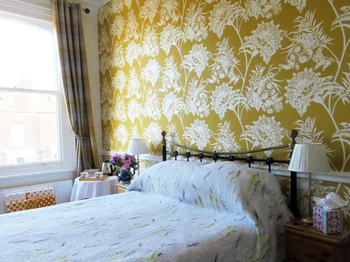 约克阿万达宾馆的一间卧室配有一张带花卉壁纸的床