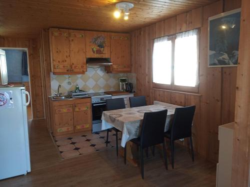 普雷芒翁达里亚公寓的厨房配有桌椅和冰箱。