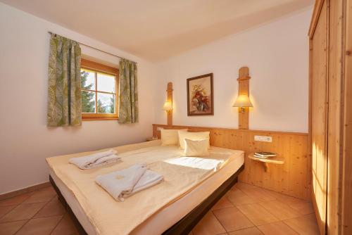 克尼格利斯滕索内克公寓式酒店的一间卧室配有一张床,上面有两条毛巾