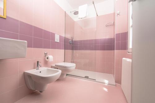 拉利奥Albergo Diffuso Ca' Spiga的粉红色的浴室设有卫生间和水槽