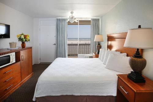 怀尔德伍德Aquarius Oceanfront Inn的一间设有大床和窗户的酒店客房