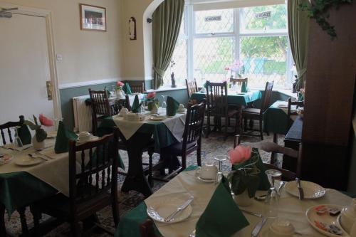 布里德灵顿贝尔蒙特旅馆的餐厅配有桌椅和绿色的桌布