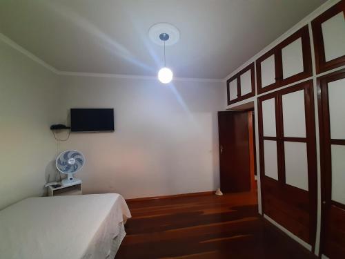 圣若昂-德雷Casa da Tuca的一间卧室配有一张床、一个风扇和一台电视。