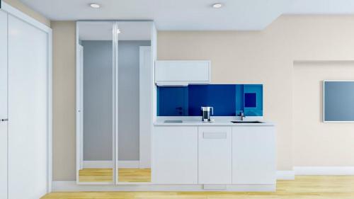 巴统Orbi City Relax的白色的厨房配有水槽和蓝色橱柜