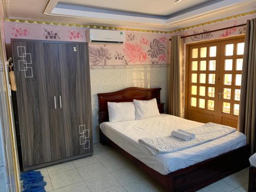 胡志明市Minh Tuan Hotel的一间卧室配有一张床和一个大衣柜