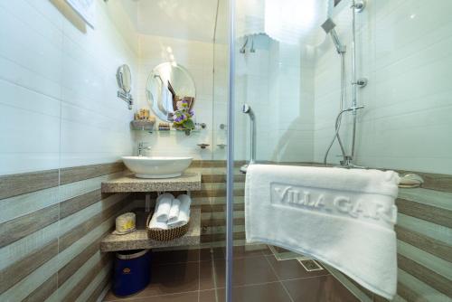 会安VIP Garden Villa and Pool Hội an的一间带水槽和玻璃淋浴的浴室
