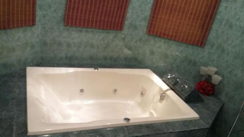 马萨特兰residencia 2的浴室铺有绿色瓷砖,配有白色浴缸。