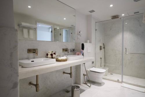 斋浦尔Brij Nest, Jaipur - An All Suite Boutique Hotel的一间带两个盥洗盆、淋浴和卫生间的浴室