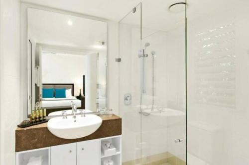 棕榈湾Beach Club Palm Cove的白色的浴室设有水槽和淋浴。
