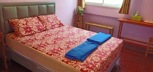 曼谷santo house的一张带红毯和蓝色枕头的床