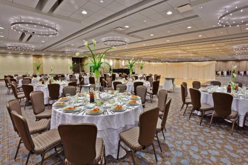 罗斯芒特芝加哥奥黑尔皇冠广场酒店与会议中心的宴会厅配有白色的桌椅