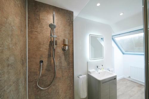 德拉姆纳德罗希特Woodlands Bed & Breakfast的带淋浴和盥洗盆的浴室
