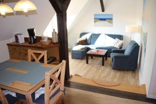 伯尔格伦德-雷特维施我的钓鱼小屋旅馆的客厅配有蓝色的沙发和桌子