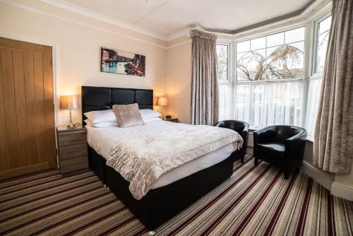 马奇铜锣湾旅馆的一间卧室配有一张床、两把椅子和一个窗户