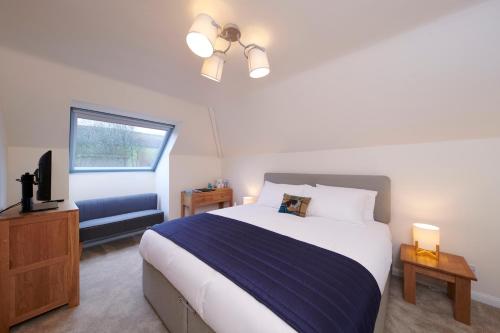 德拉姆纳德罗希特Woodlands Bed & Breakfast的一间卧室配有一张大床和电视