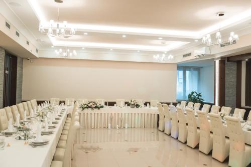 SemičHOTEL SMUK的宴会厅配有白色的桌椅