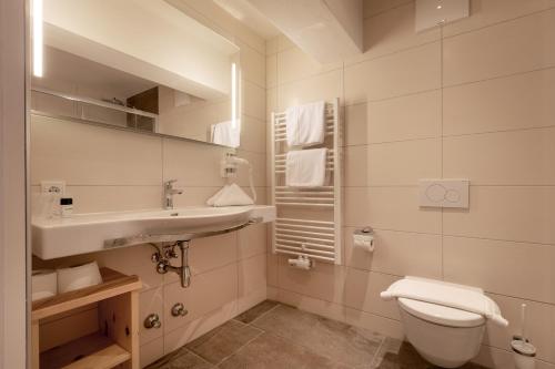 明施特尔Hotel Hauserwirt的白色的浴室设有水槽和卫生间。