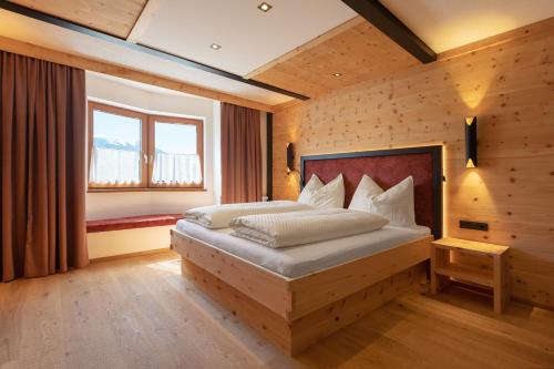 明施特尔Hotel Hauserwirt的卧室配有一张床铺,位于带木墙的房间内