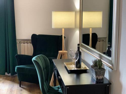 锡耶纳拉科罗西纳公寓式酒店的客厅配有椅子、桌子和镜子