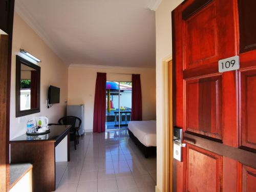 珍南海滩卡萨伊达曼汽车旅馆的带卧室、床和厨房的客房