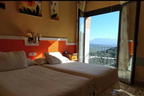 卢塞纳Hotel Sierra de Araceli Lucena的一间卧室设有两张床和大窗户