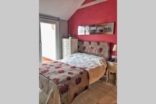 卡马斯Duplex, terraza, 10 min coche centro Sevilla的一间卧室设有一张床和红色的墙壁