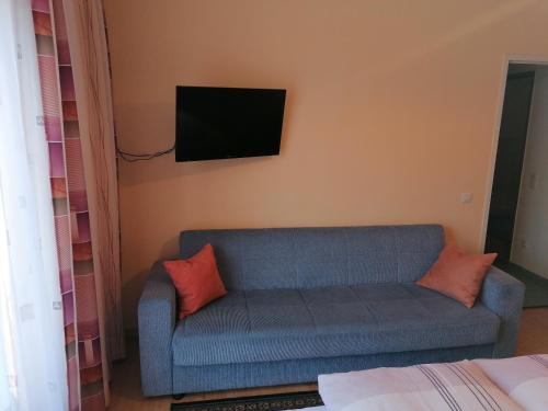 OberlienzFerienhaus Mattersberger的客厅配有蓝色的沙发和墙上的电视