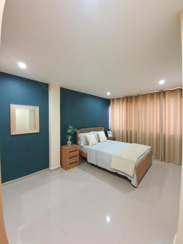 普拉亚kelly's House Plateau City Center的一间卧室设有一张床和蓝色的墙壁