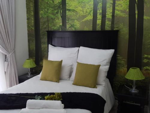 范德拜尔帕克Casa Angelo的一间卧室配有一张带白色枕头的床和绿色墙壁。