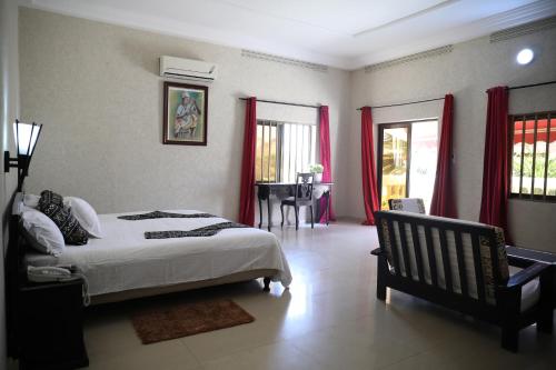 洛美马迪巴公寓式酒店的卧室配有床、桌子和窗户。