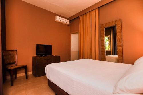 塔里法特里斯马里斯休闲酒店的一间卧室配有一张床、一台电视和一把椅子